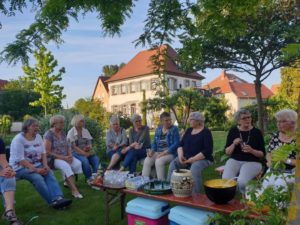 Anschlussplausch an die Maiandacht mit Pfarrhaus im Hintergrund